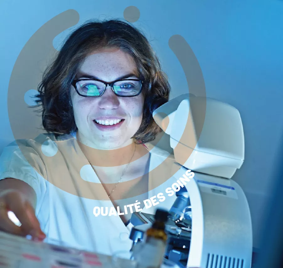 Une jeune femme en blouse blanche et lunettes, souriante, manipule un appareil de laboratoire médical sous une lumière bleutée, avec l'inscription "QUALITÉ DES SOINS" intégrée dans un élément graphique circulaire.